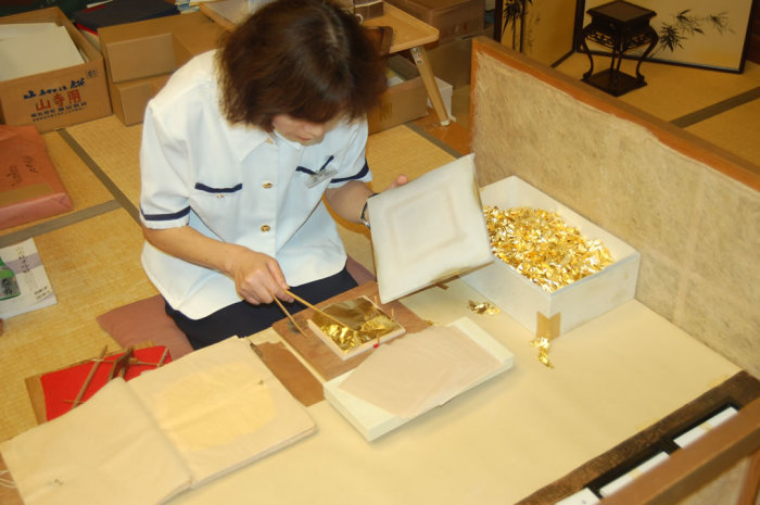 A gentle nudge and poke with the two wooden sticks, a breath of air, and the sheet is flat and centered within the stack.